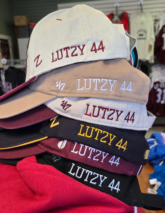 Collection of hats with 'LUTZY 44' text embroidered in various colors on a rack.