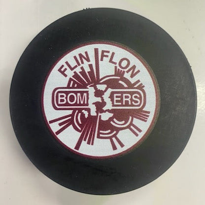 Black hockey puck with 'Flin Flon Bombers' logo on a white background