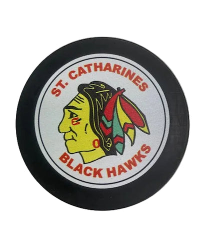 Hockey puck with St. Catharines Black Hawks logo on a white background